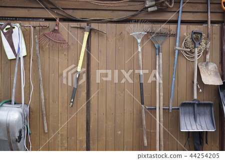 shovels rakes hammers hanging on wooden wall shovels rakes hammers hanging on wooden wall 44254205