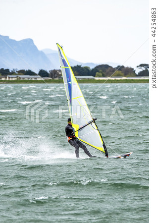 Man windsurfing close to the town of Caernarfon in Wales - United Kingdom Man windsurfing close to the town of Caernarfon in Wales - United Kingdom 44254863