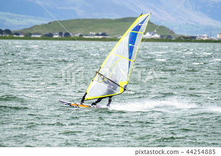 Man windsurfing close to the town of Caernarfon in Wales - United Kingdom Man windsurfing close to the town of Caernarfon in Wales - United Kingdom 44254885