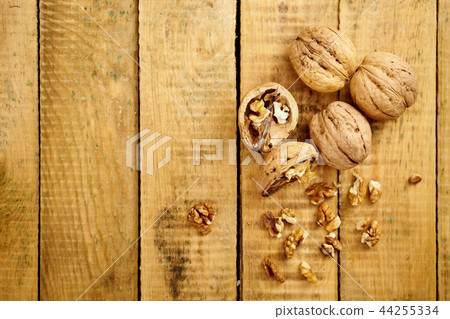 delicious and fresh crushed walnuts on a wooden table delicious and fresh crushed walnuts on a wooden table 44255334