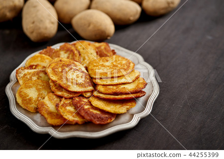 delicious golden potato pancakes on an old wooden black table 44255399