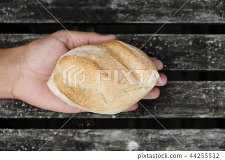 man with a bread roll in his hand 44255512