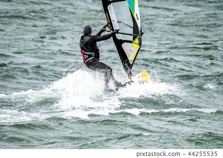 Man windsurfing close to the town of Caernarfon in Wales - United Kingdom Man windsurfing close to the town of Caernarfon in Wales - United Kingdom 44255535