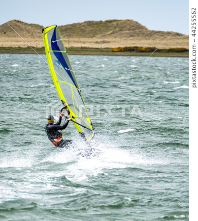Man windsurfing close to the town of Caernarfon in Wales - United Kingdom 44255562