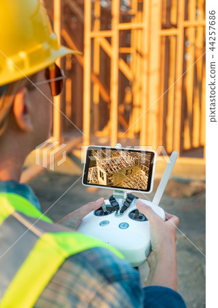 Female Drone Pilot Inspecting a Construction Site Female Drone Pilot Inspecting a Construction Site 44257686