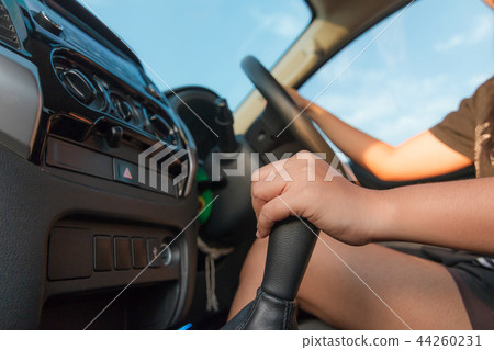 Hand of woman touching gear transmission of SUV Hand of woman touching gear transmission of SUV 44260231