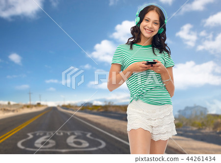 teenage girl in phones with smartphone on route 66 teenage girl in phones with smartphone on route 66 44261434