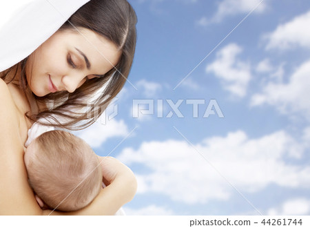 mother breast feeding baby over sky background mother breast feeding baby over sky background 44261744