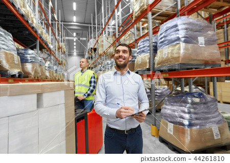 happy businessman with clipboard at warehouse 44261810