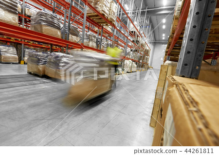 worker carrying loader with goods at warehouse 44261811