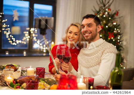 couple taking picture by selfie stick at christmas 44261964