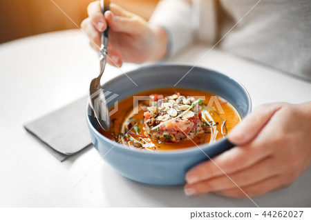 woman eating pumpkin cream soup at restaurant woman eating pumpkin cream soup at restaurant 44262027