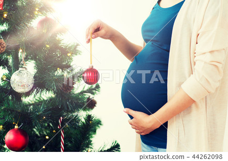 pregnant woman decorating christmas tree 44262098