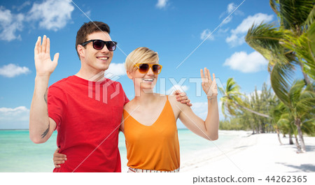 couple in sunglasses hugging and waving hands couple in sunglasses hugging and waving hands 44262365