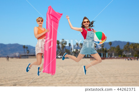 teenage girls jumping with beach ball and mattress teenage girls jumping with beach ball and mattress 44262371