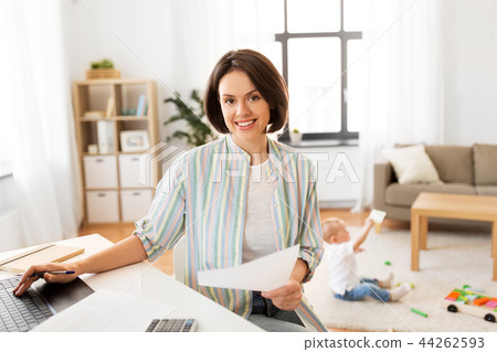 mother working at laptop and baby playing at home 44262593