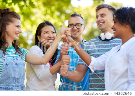 happy friends making thumbs up in park happy friends making thumbs up in park 44262646