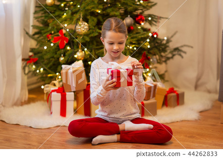 smiling girl with christmas gift at home smiling girl with christmas gift at home 44262833