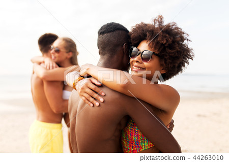 happy friends or couples hugging on summer beach happy friends or couples hugging on summer beach 44263010