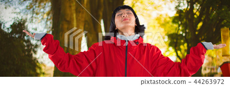 Composite image of blissful woman standing with arms outstretched 44263972