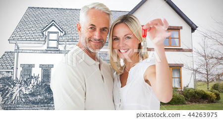 Composite image of happy couple showing their new house key 44263975