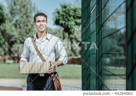 Serious male courier getting delivery in time 44264063