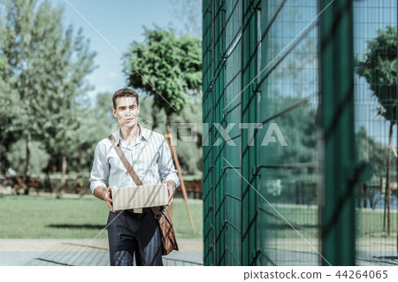 Attractive male courier performing delivery in time Attractive male courier performing delivery in time 44264065