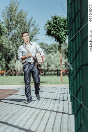 Handsome male courier bringing package to client Handsome male courier bringing package to client 44264066