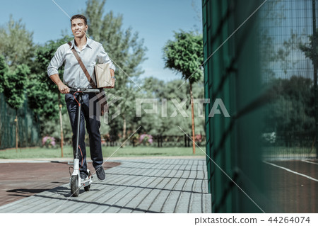 Glad male courier delivering package on scooter 44264074