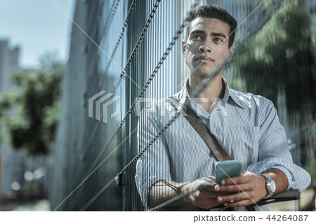 Musing handsome guy calling online on phone Musing handsome guy calling online on phone 44264087