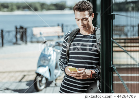 Pensive charming guy replaying on message immediately Pensive charming guy replaying on message immediately 44264709