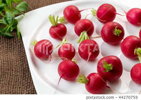 Fresh radish on white plate.  44270759