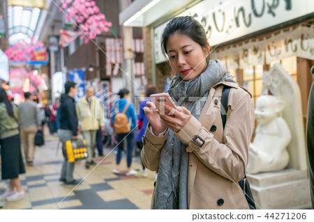 woman using cellphone to contact her friend 44271206