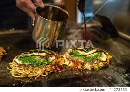 okonomiyaki is almost done on the iron plate okonomiyaki is almost done on the iron plate 44272563