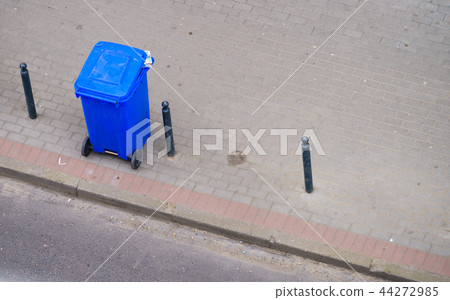 Blue trash can on street pavement 44272985