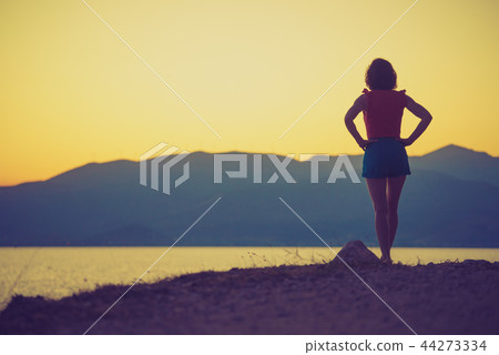 Woman relaxing on coastline Woman relaxing on coastline 44273334