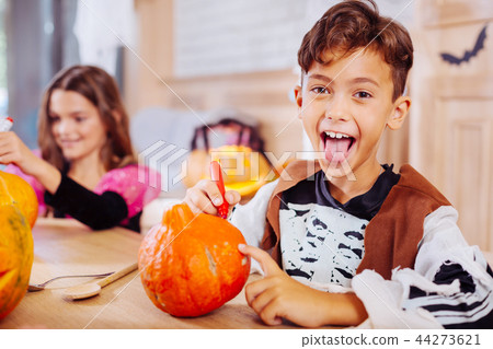 Cute boy wearing Halloween costume showing his tongue feeling excited 44273621
