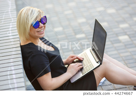 young girl with laptop smiling outdoors 44274667