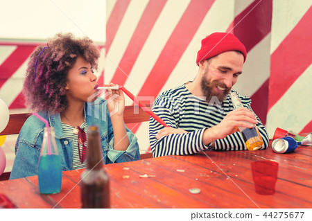 Positive couple sitting at the table and continuing their party 44275677