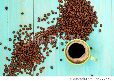 Green cup of coffee and coffee beans 44277639