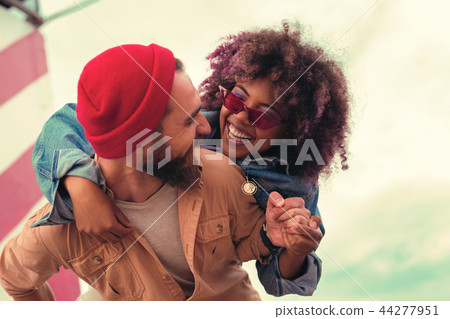Young woman feeling happy while sitting on the back of her beloved man Young woman feeling happy while sitting on the back of her beloved man 44277951