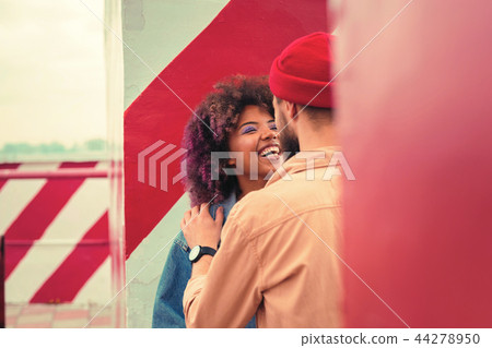 Young man putting hand on the shoulder of his laughing young girlfriend Young man putting hand on the shoulder of his laughing young girlfriend 44278950