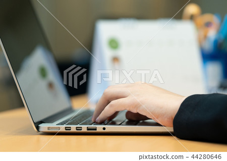 Office worker Using a portable computer on a desk 44280646