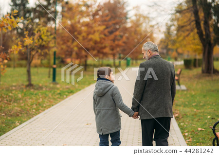 Back view of grandpa and grandson in park. Childhood. autumn Back view of grandpa and grandson in park. Childhood. autumn 44281242