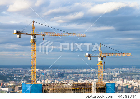 cranes at top of skyscraper under construction 44282384