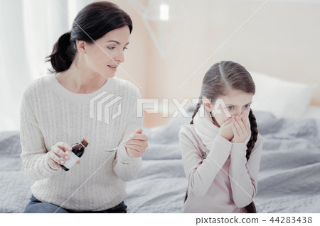 Close up of careful mother with mixture for her daughter 44283438