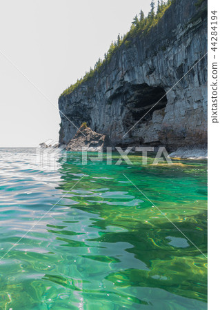 Bright clear aqua green water on Bruce Peninsula with big limest Bright clear aqua green water on Bruce Peninsula with big limest 44284194