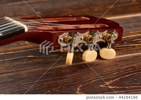 Head of acoustic guitar on wooden background. 44284198
