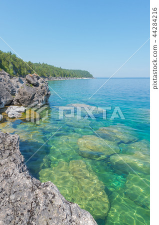 Bright clear aqua green water on Bruce Peninsula with big limest Bright clear aqua green water on Bruce Peninsula with big limest 44284216