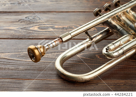 Aged trumpet on wooden background. 44284221